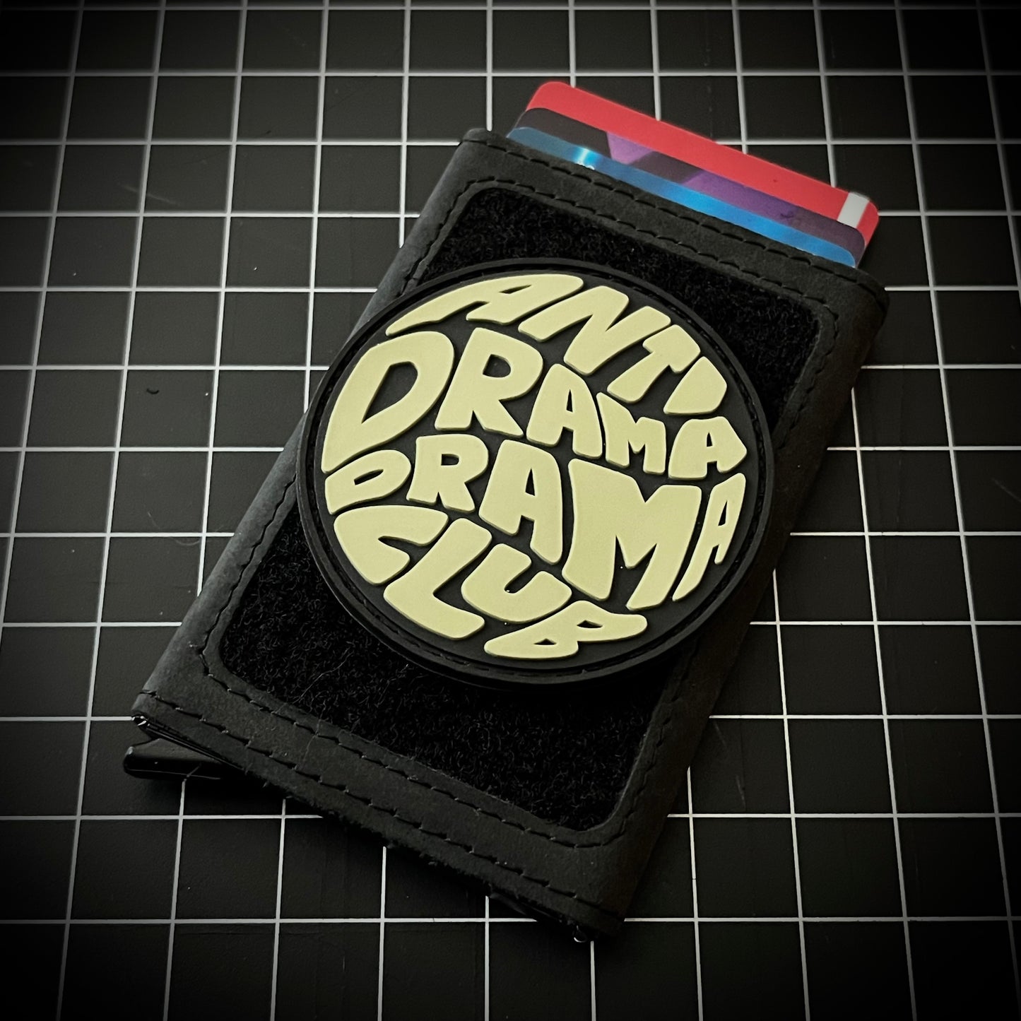Anti Drama Drama Club RE PVC ranger eye morale patch on a velcro wallet and grid background.