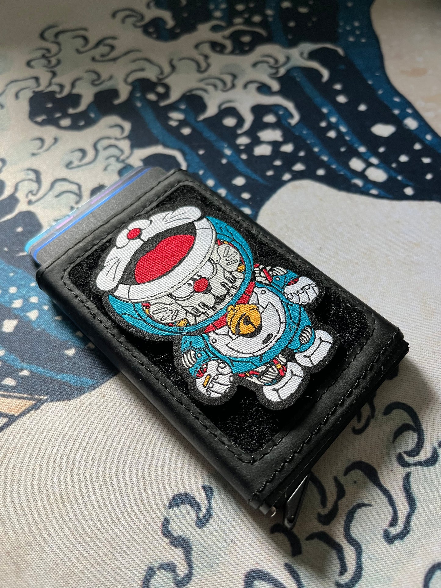 Doraemon Patch Set showing a blue mechanical cartoon cat embroidery patch on a velcro wallet with a Great Wave background.