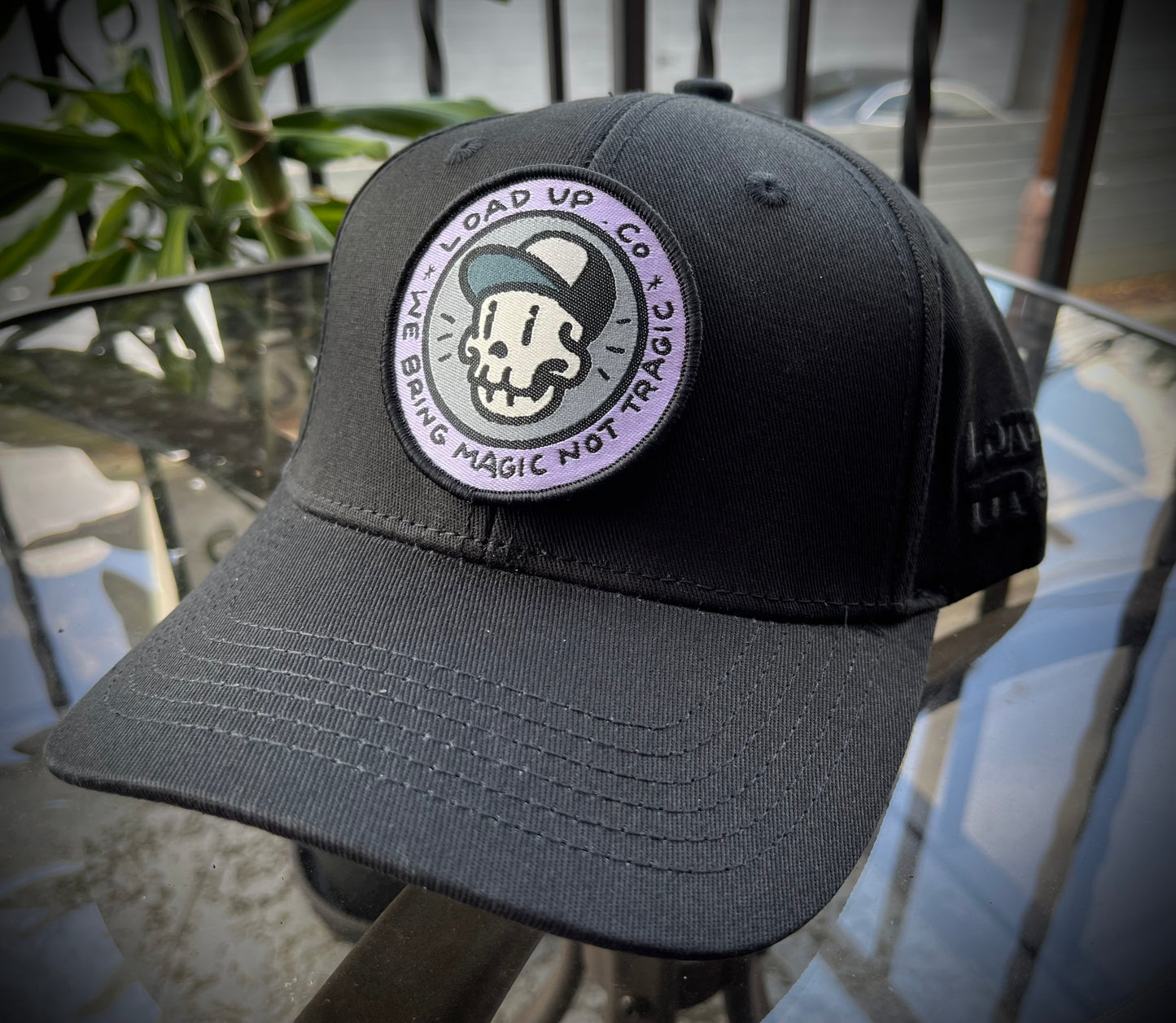 LOADUP.CO Magic Not Tragic Patch circle patch featuring a skull design with a cap and text that says LOADUP CO WE BRING MAGIC NOT TRAGIC on a baseball cap.