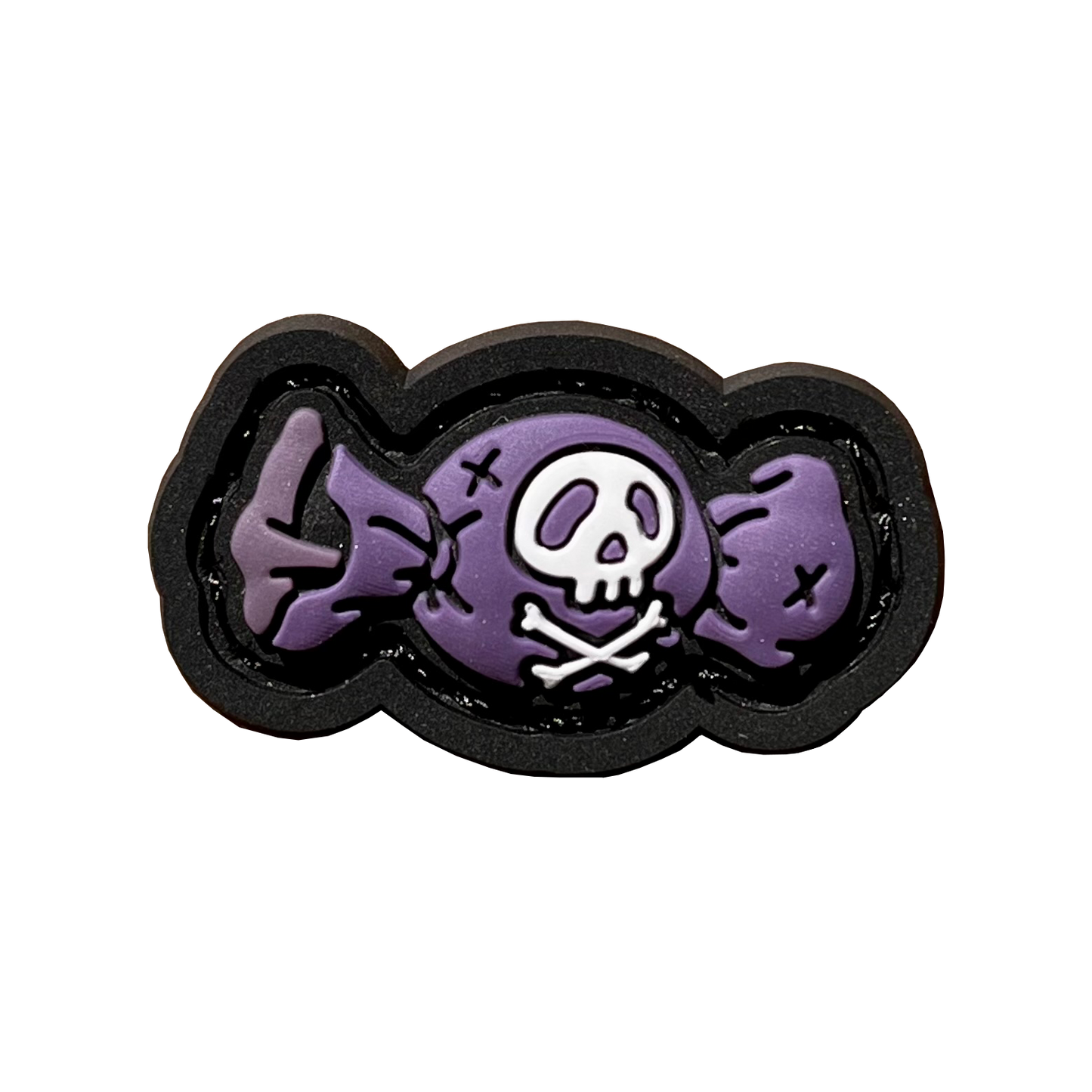 Piece of candy in a purple wrapper featuring a skull and crossbones on the front.