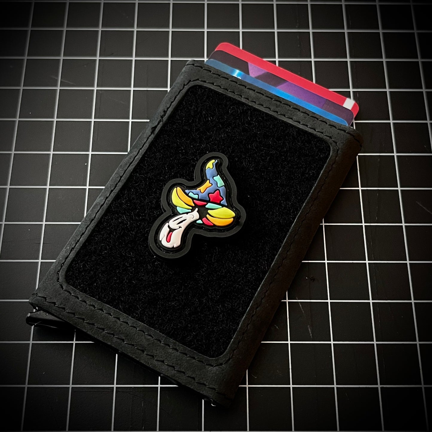 Shroomie RE - Candy PVC ranger eye morale patch of a colorful mushroom character on a velcro wallet and grid background.