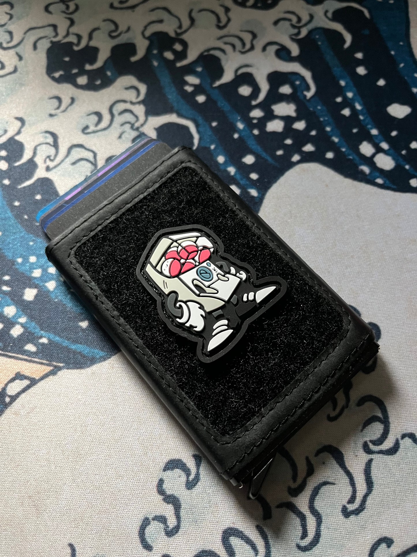 Gashapon RE ranger eye morale patch showing a white gashapon Japanese game character with arms and legs on a velcro wallet with a Great Wave background.