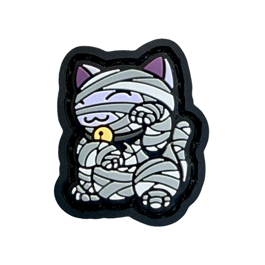 Mummy Neko RE Halloween ranger eye velcro patch depicting a cat wrapped as a mummy in a maneko lucky cat pose.