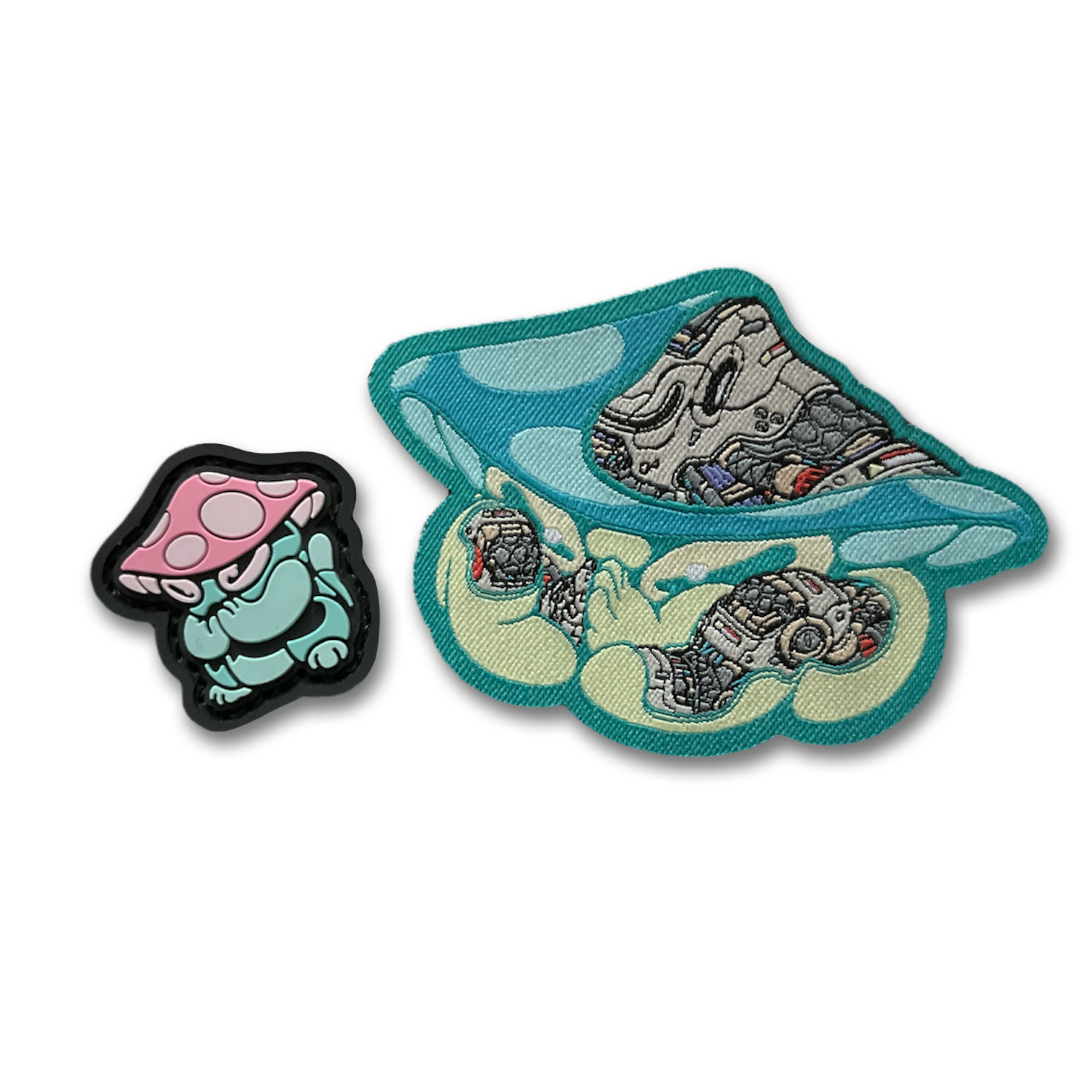 Praying Mushroom Patch Set depicting 2D PVC patch of a green mushroom character with pink and white cap in a lucky cat maneko pose and a woven nylon mechanical style green mushroom patch.