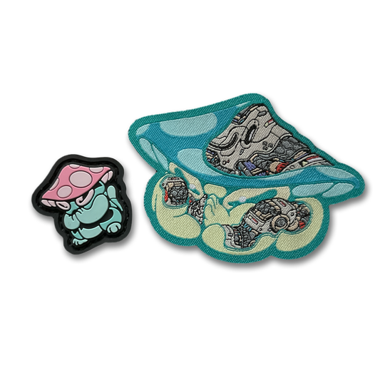 Praying Mushroom Patch Set depicting 2D PVC patch of a green mushroom character with pink and white cap in a lucky cat maneko pose and a woven nylon mechanical style green mushroom patch.
