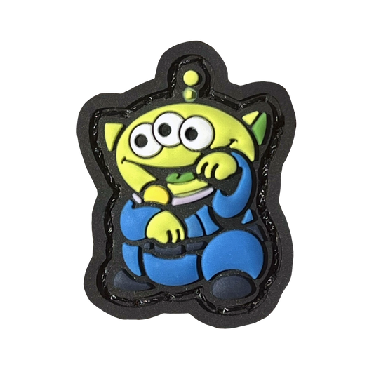 Alien Neko RE PVC ranger eye morale patch of a green alien with three eyes wearing a blue outfit sitting in a lucky cat maneki-neko pose.