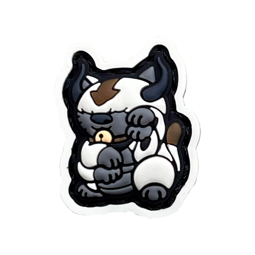 Appa Neko RE PVC ranger eye morale patch of a white bison with brown arrow on its forehead sitting in a lucky cat maneki-neko pose.