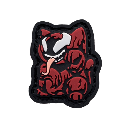 Crimson Monster Neko RE PVC ranger eye morale patch of a red cartoon character with its tongue sticking out sitting in a lucky cat maneki-neko pose.