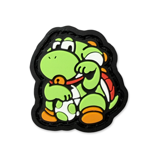 Ranger eye pvc morale patch of a green dinosaur holding an egg in a lucky cat maneki neko pose