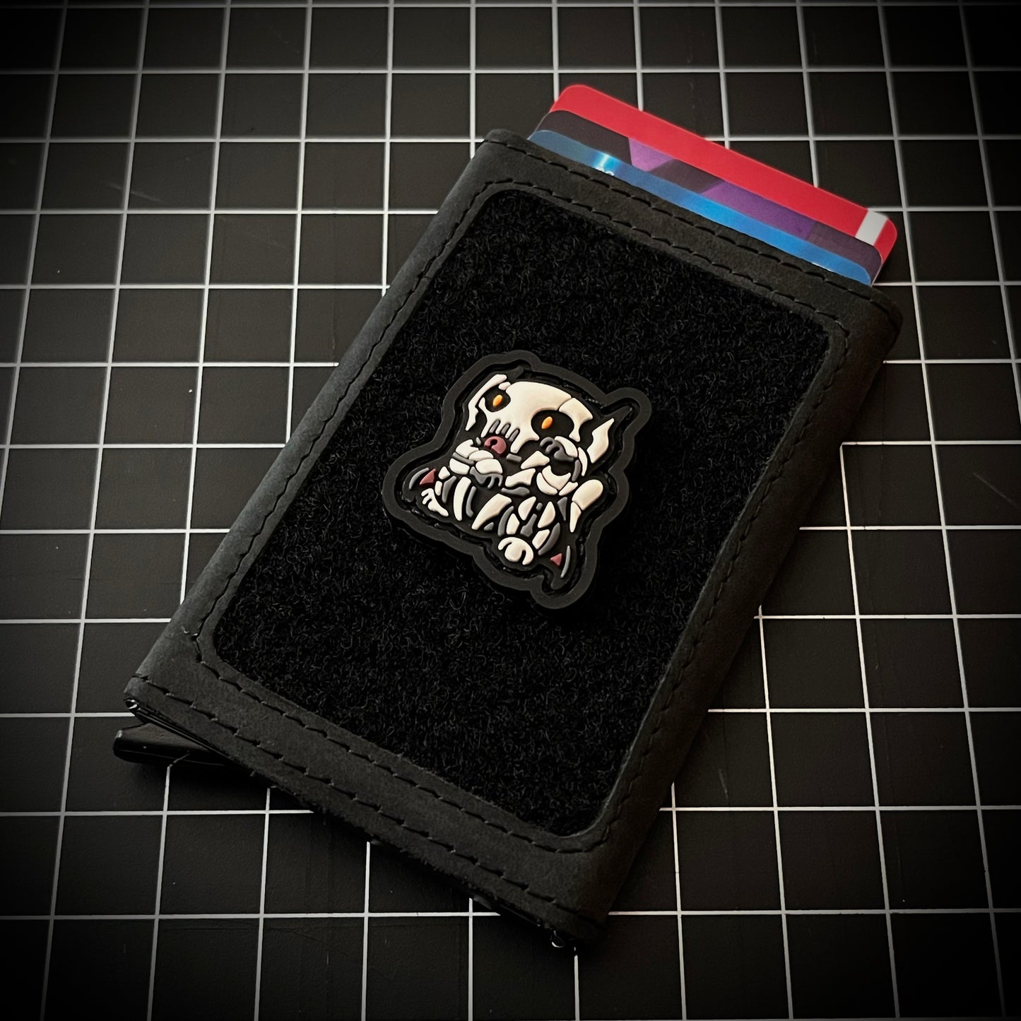 General Grievous Neko RE PVC ranger eye morale patch of a robotic white character in a lucky cat maneki-neko pose on a velcro wallet and grid background.