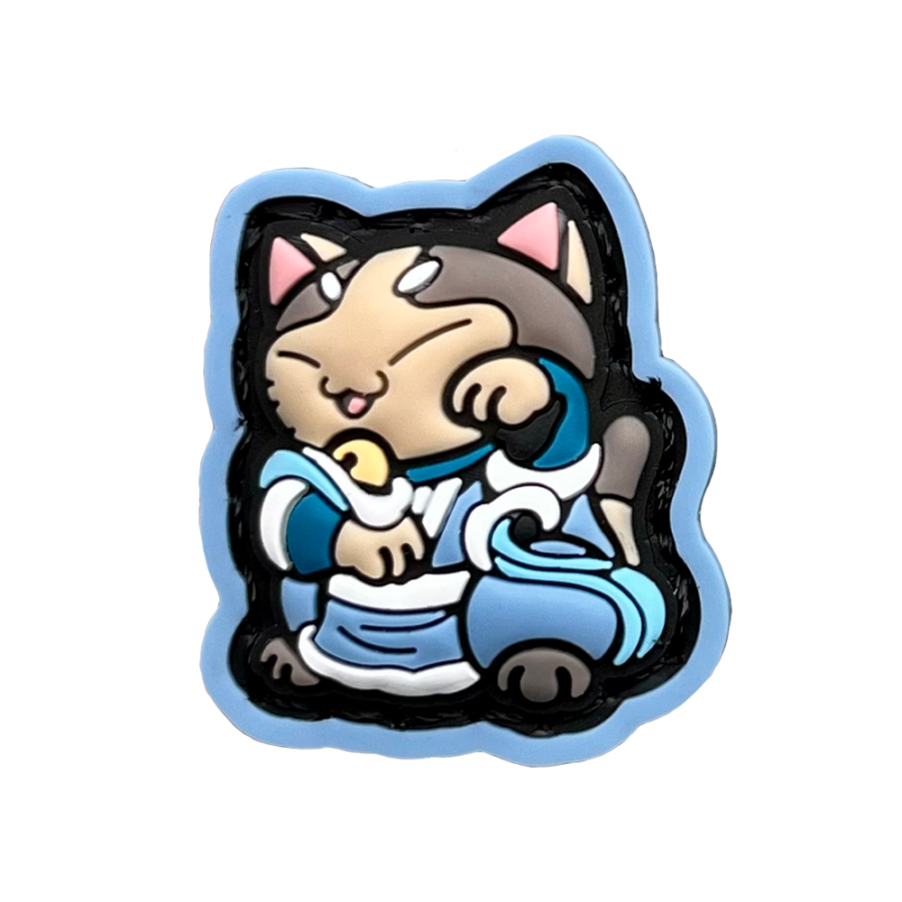 Katara Neko RE PVC ranger eye morale patch of a cartoon character girl cat with brown hair and blue clothes sitting in a lucky cat maneki-neko pose.