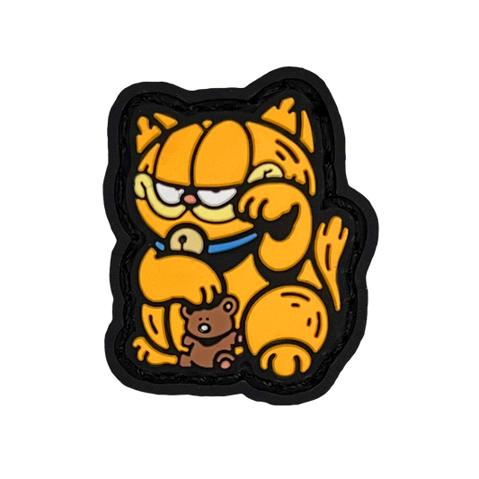 Lazy Lasagna Lover Neko RE PVC ranger eye morale patch of an orange cat holding a teddy bear sitting in a lucky cat maneki-neko pose.