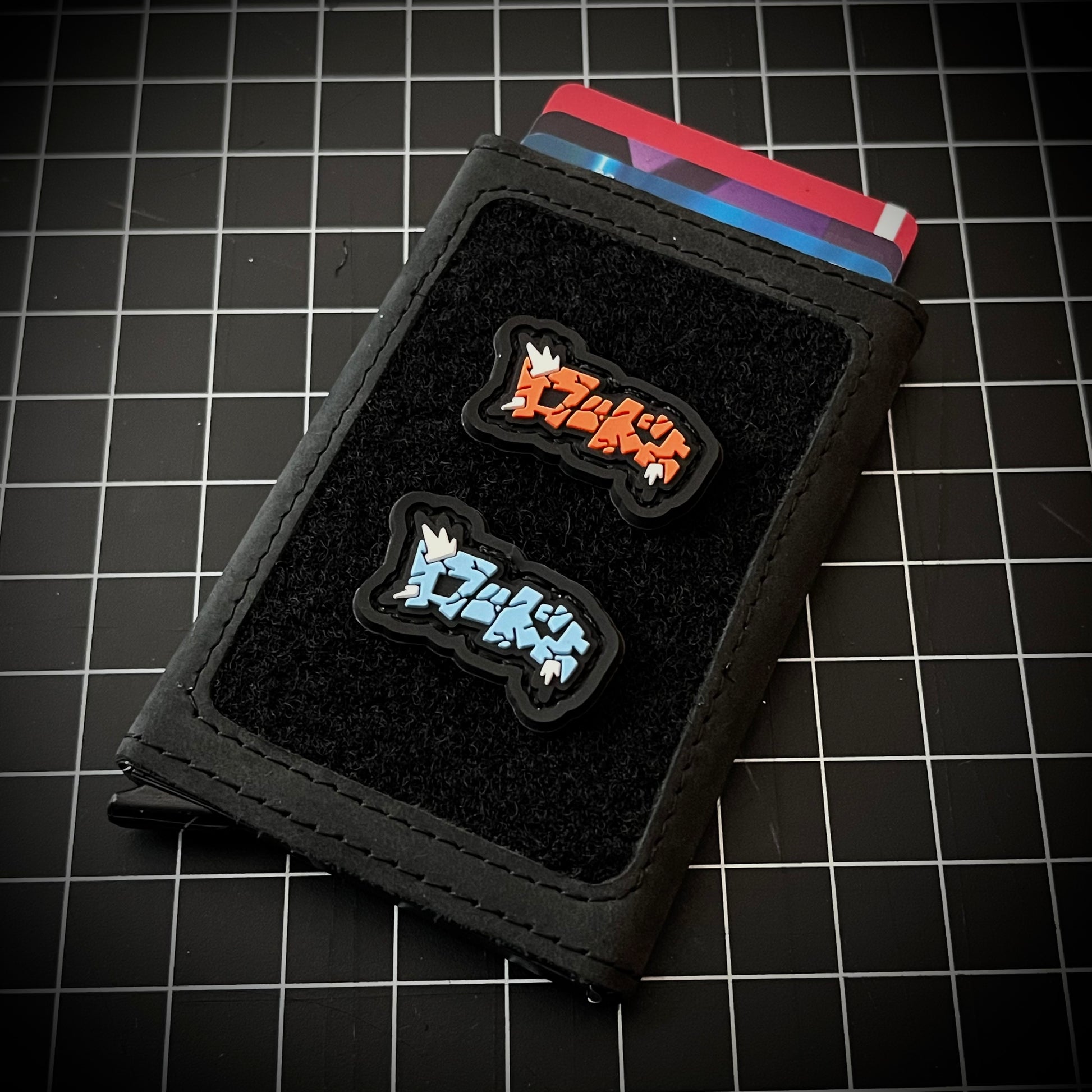 LoadUp Kanji RE - Blue and Red PVC ranger eye morale patches of  logo patches depicting the word 'Load Up' in japanese kanji on a velcro wallet and grid background.