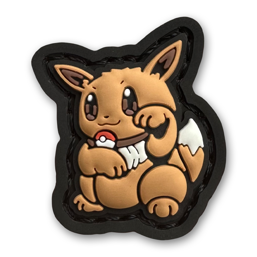 Monster 133 Neko RE PVC ranger eye morale patch of a brown monster character sitting in a lucky cat maneki-neko pose.