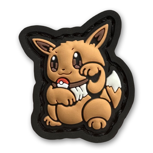Monster 133 Neko RE PVC ranger eye morale patch of a brown monster character sitting in a lucky cat maneki-neko pose.