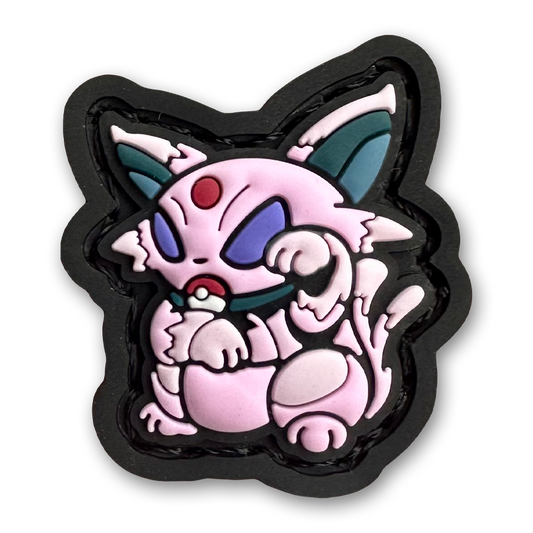 Psychic Monster Neko RE PVC ranger eye morale patch of a pink monster character sitting in a lucky cat maneki-neko pose.