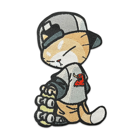 Skate Cato Patch woven nylon morale patch of an orange cat wearing a backwards hat and Toy Machine shirt holding a skateboard 