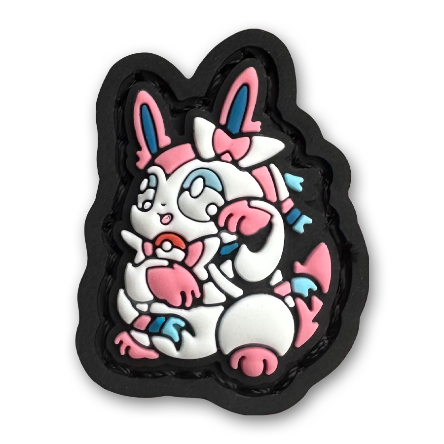 Sylveon Neko RE PVC ranger eye morale patch of a pink and white monster character sitting in a lucky cat maneki-neko pose.
