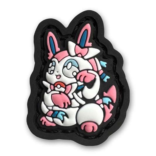 Sylveon Neko RE PVC ranger eye morale patch of a pink and white monster character sitting in a lucky cat maneki-neko pose.