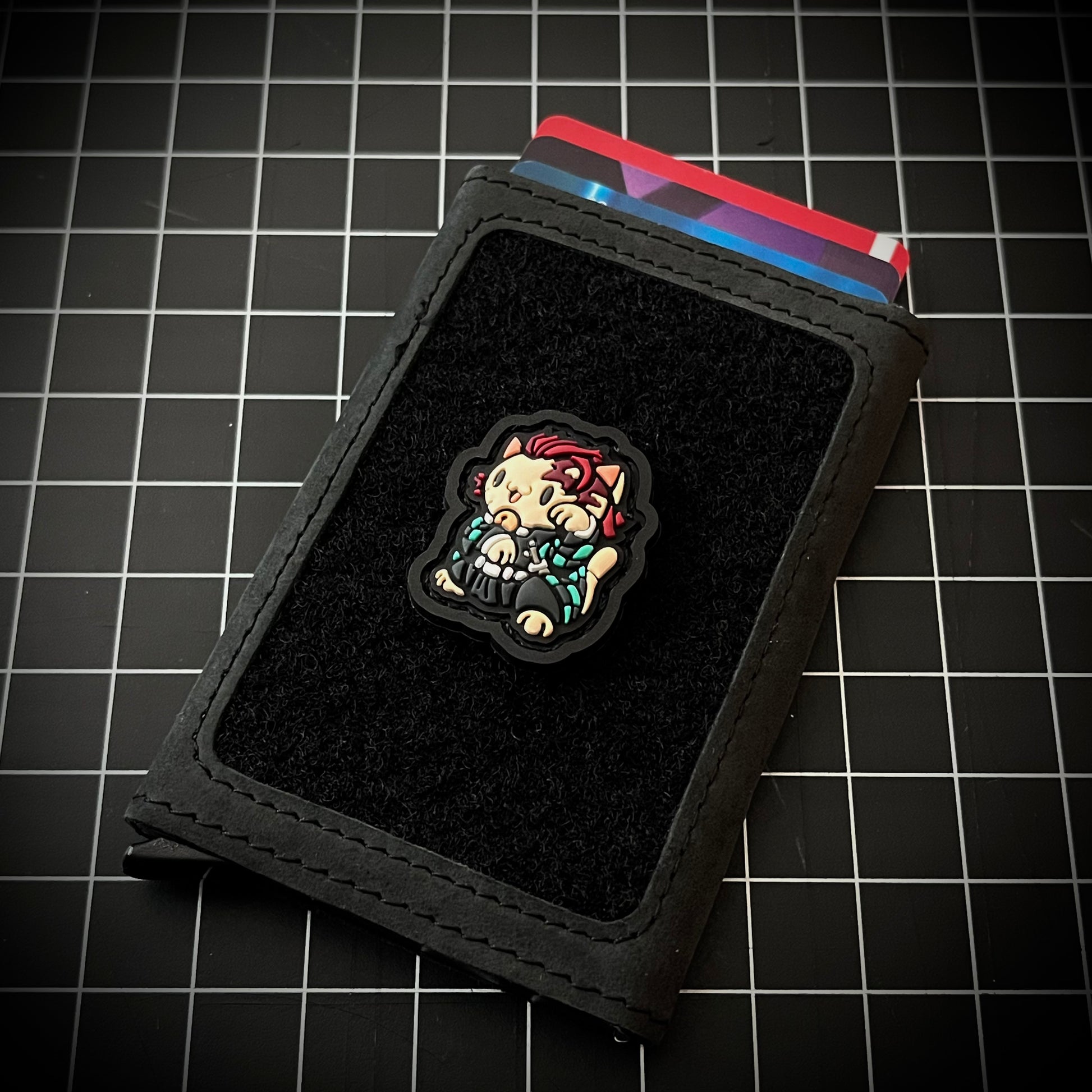 Tanjiro Neko RE PVC ranger eye patch maneki-neko slayer character in a lucky cat maneko pose on a wallet and grid background.